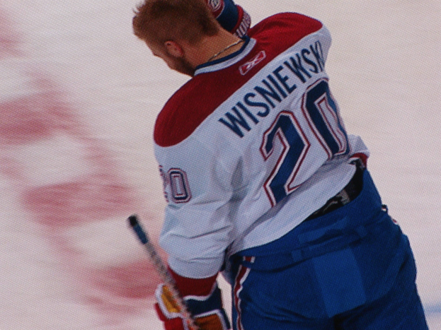 Ein Hockey-Spieler im Jersey mit der Aufschrift "Wisniewski" steht auf dem Eis und hält einen Hockey-Schläger in der Hand.