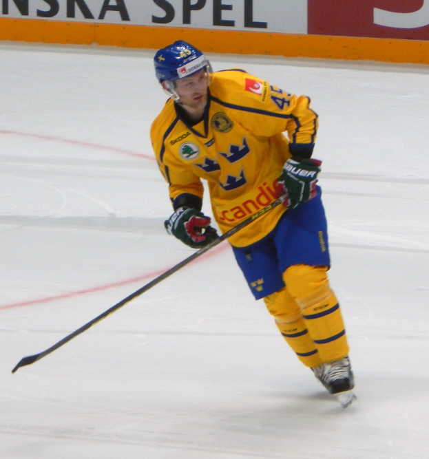 Eishockeyspieler in Bewegung auf dem Eis mit Helm, Handschuhen und Schlittschuhen, der einen Hockey-Schläger hält, mit einer textgefüllten Tafel im Hintergrund.