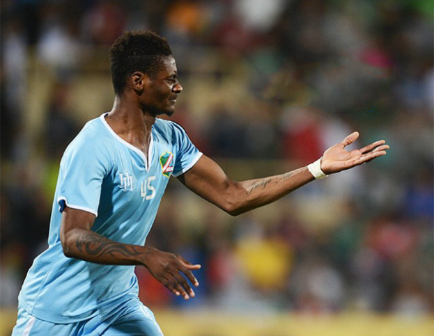 Ein Fußballspieler in einem blauen Trikot feiert nach einem Tor mit ausgestreckten Armen.