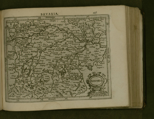 Offenes Buch mit detaillierter Karte von Bayern und umgebendem Text, der die Region und ihre Bewohner beschreibt.