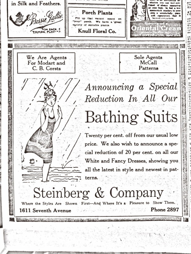 Eine Frau in einem weißen hochgeschlossenen, langärmeligen Kleid mit einem Dutt, die in der Mitte einer Steinberg & Company-Badeanzugwerbung steht.