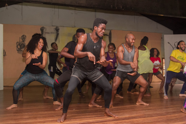 Eine Gruppe von Menschen, die in einem Raum mit Gemälden an den Wänden und einer Decke darüber tanzen, wahrscheinlich Teil eines Choreografie-Kurses an der Universität Chicago.