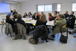 Eine Gruppe von Menschen, die sich unterhält, mit zwei Personen im Hintergrund, die miteinander sprechen.