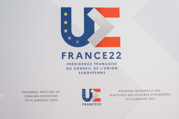 Plakat für die "Frankreich 22 - Inoffizielle Zusammenkunft der Außenminister" mit dem Logo der Europäischen Union, das einen blauen Kreis mit einem weißen Stern und schwarzen zentrierten Text zeigt.