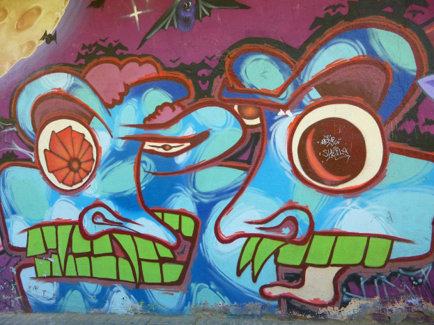 Ein lebendiges, farbenfrohes Wandgemälde mit Graffiti-Kunst an der Seite eines Gebäudes.