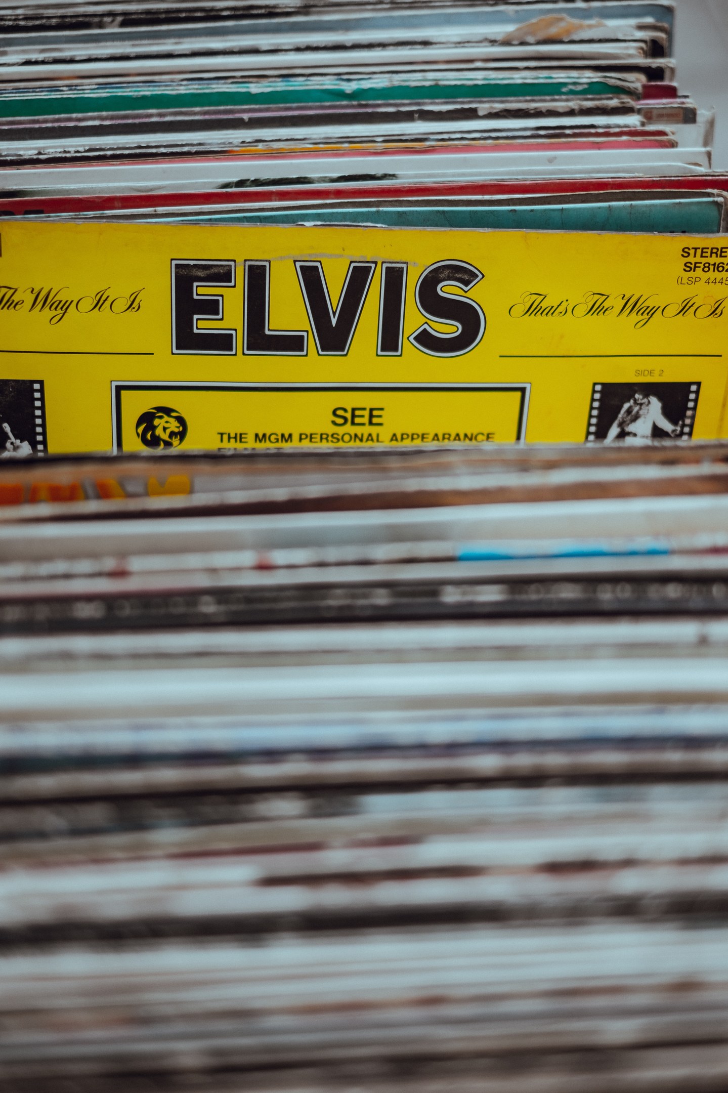 Stapel von Elvis-Presley-Schallplatten, ordentlich übereinander auf einem Tisch mit sichtbaren Titeln und einem sanft unscharfen Hintergrund.