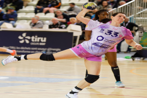 Eine Gruppe von Frauen, die Handball auf einem Court spielen, mit einem Ball in der Mitte und Zuschauern im Hintergrund, die das Spiel bei der Futsal-Weltmeisterschaft 2019 in Paris, Frankreich, verfolgen.