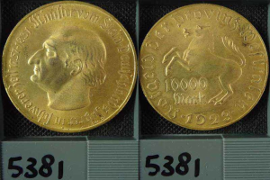 Zwei Goldmünzen in einer Schachtel, eine mit dem Kopf eines Mannes, beide mit Zahlen darauf.