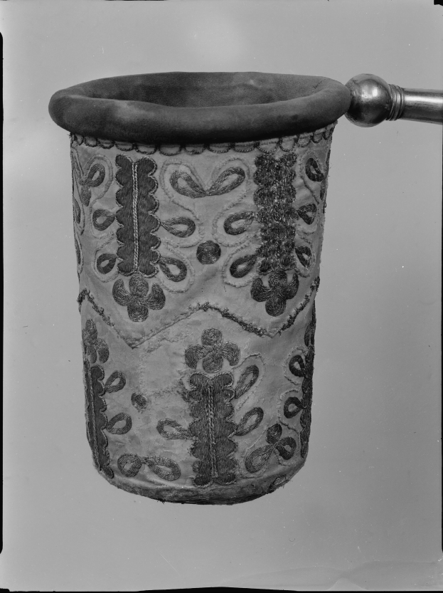 Ein Schwarz-Weiß-Foto eines Stoff-Mülleimer mit Griff.